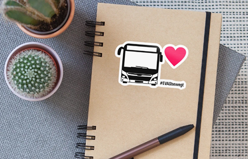 Notizbuch mit EVAG-Bus-Aufkleber auf einem Tisch.