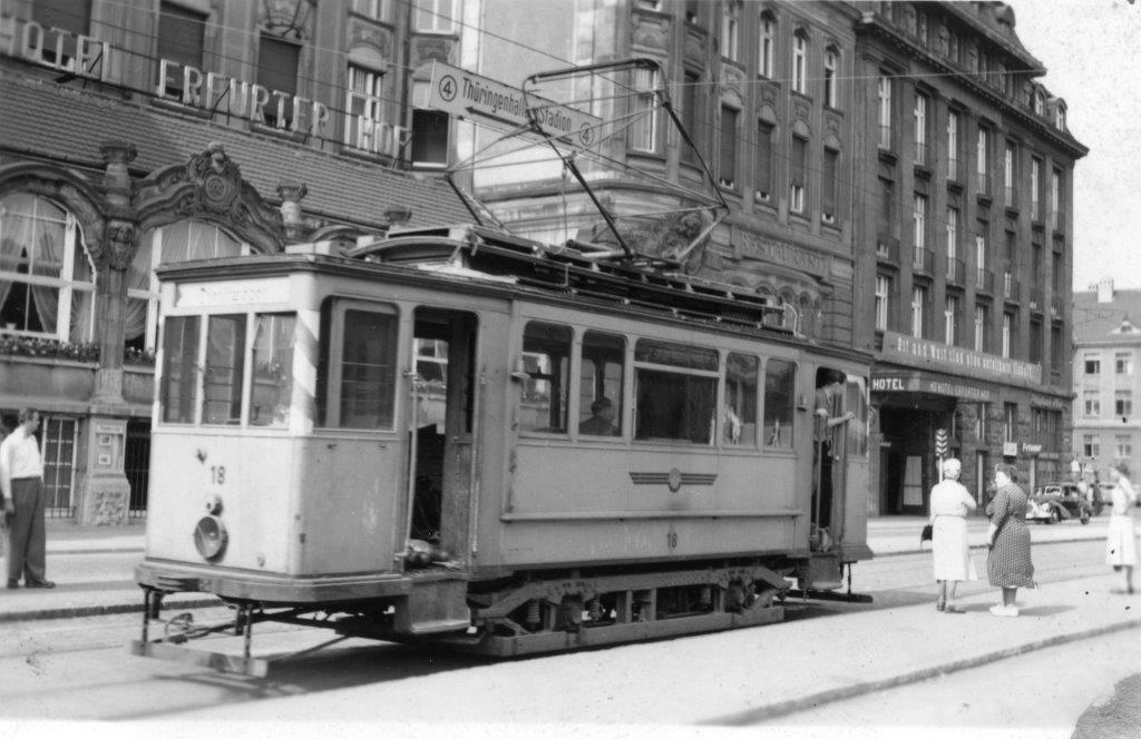 Am Bahnhofsvorplatz fährt an der Haltestelle der Linie 4 in Richtung Breitscheidstraße der blaugraue Arbeitstriebwagen 18 auf seinem Weg zum Betriebshof vorbei.