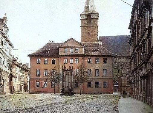 Pfarrhaus hinter der Kaufmannskirche mit Gleisen im Vordergrund.